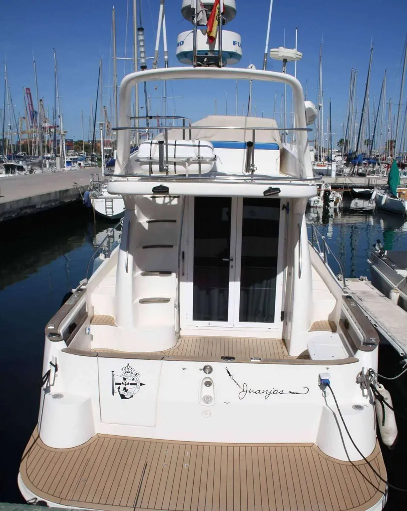 Barco privado con patrón amarrado en el puerto, listo para salir con un grupo de amigos